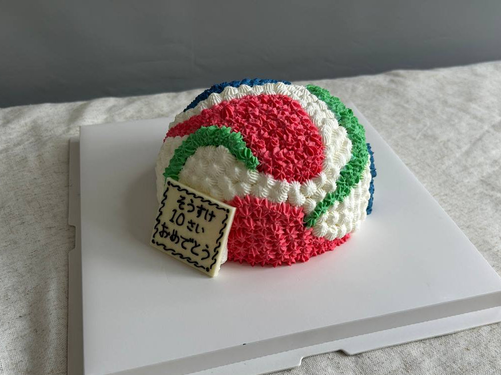 Colorful knitted ball with a small sign on a white surface custom decoration cake