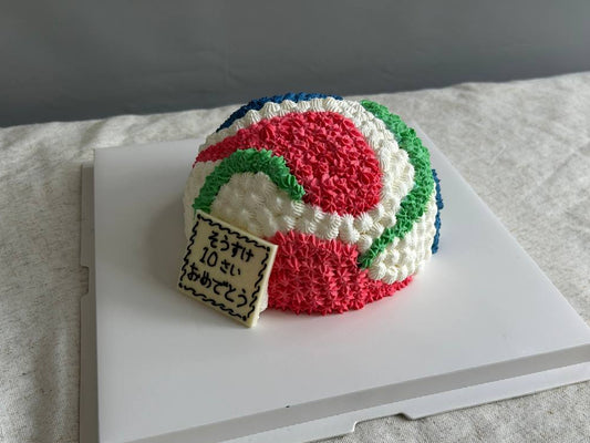 Colorful knitted ball with a small sign on a white surface custom decoration cake